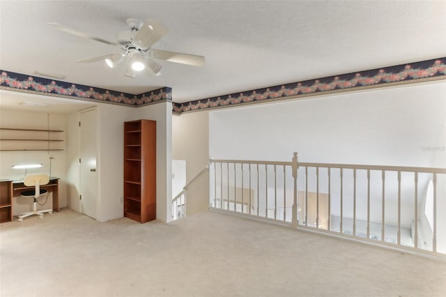 unfurnished room featuring carpet, a textured ceiling, and ceiling fan