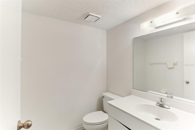 bathroom with toilet, vanity, and a textured ceiling