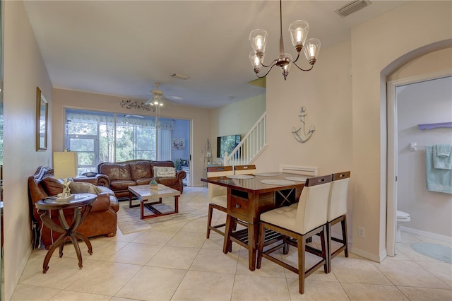 dining room featuring light tile patterned flooring and ceiling fan with notable chandelier