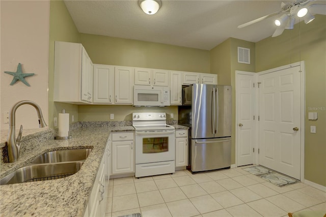 kitchen featuring sink, white cabinetry, light stone counters, and white appliances