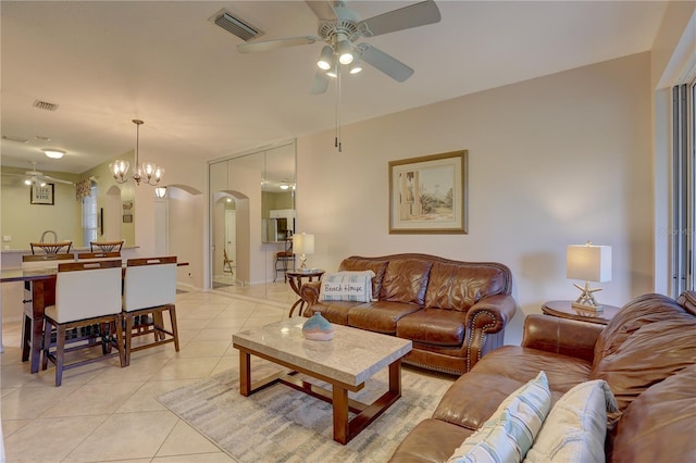 living room featuring ceiling fan with notable chandelier and light tile patterned floors