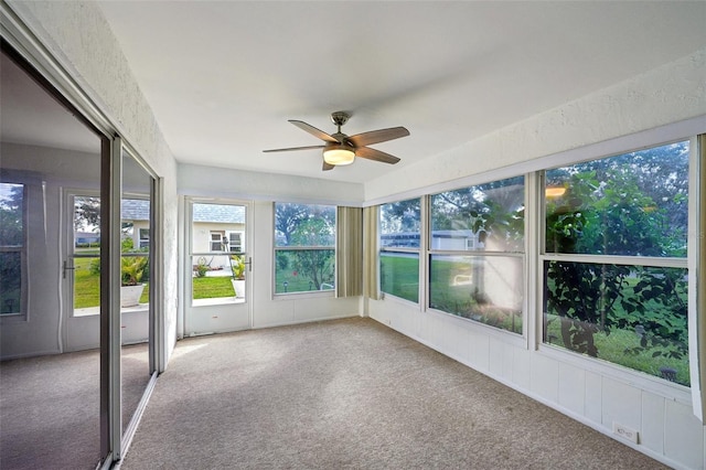 unfurnished sunroom with ceiling fan