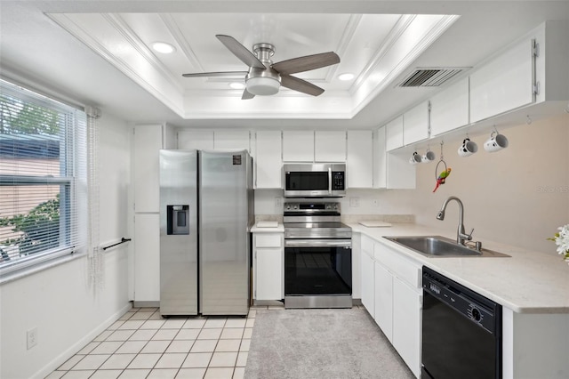 kitchen featuring sink, white cabinets, stainless steel appliances, and a raised ceiling