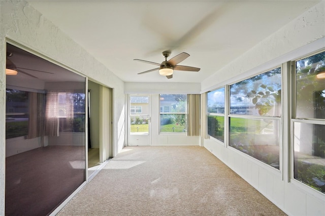 unfurnished sunroom featuring ceiling fan