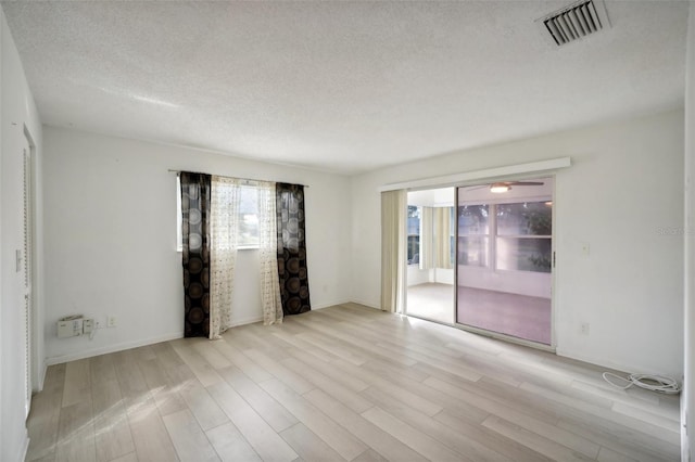 empty room featuring light hardwood / wood-style floors and a textured ceiling