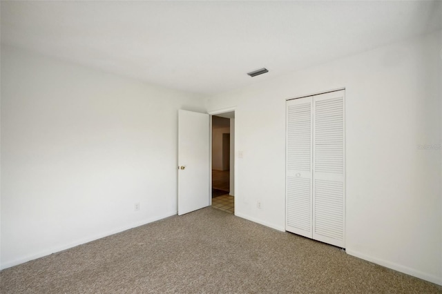 unfurnished bedroom featuring a closet and carpet flooring