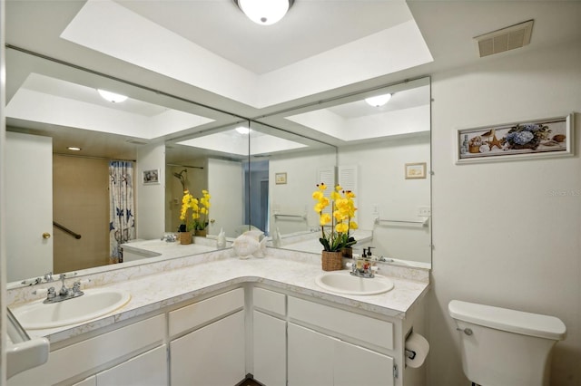 bathroom featuring vanity, curtained shower, and toilet