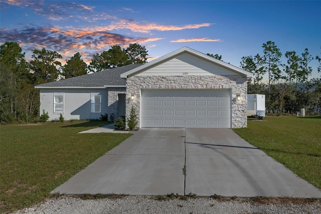 ranch-style house featuring a garage and a yard