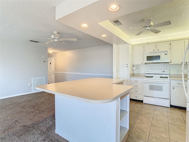 kitchen featuring light carpet, a textured ceiling, a kitchen island, and white appliances