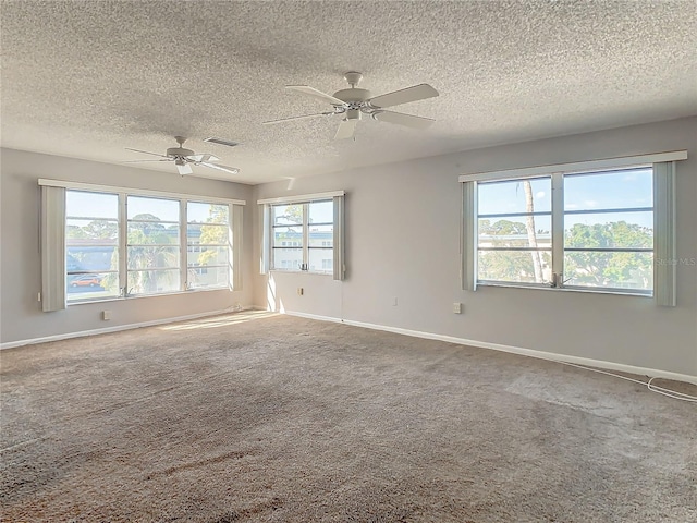 unfurnished room featuring ceiling fan, a healthy amount of sunlight, and a textured ceiling