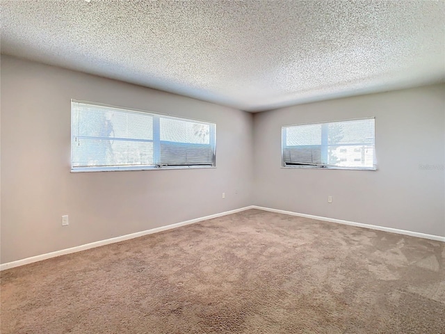 carpeted empty room featuring a textured ceiling