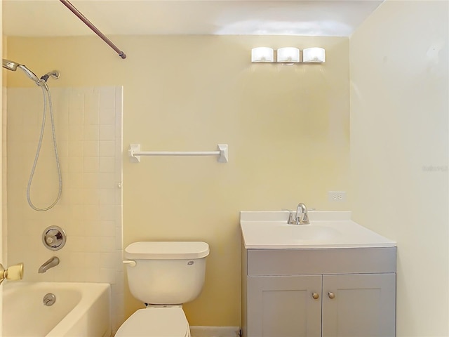 full bathroom with tiled shower / bath, vanity, and toilet