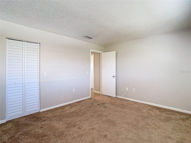 unfurnished bedroom with a closet, a textured ceiling, and carpet floors