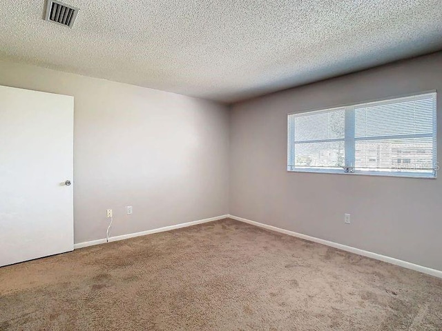 carpeted spare room featuring a textured ceiling