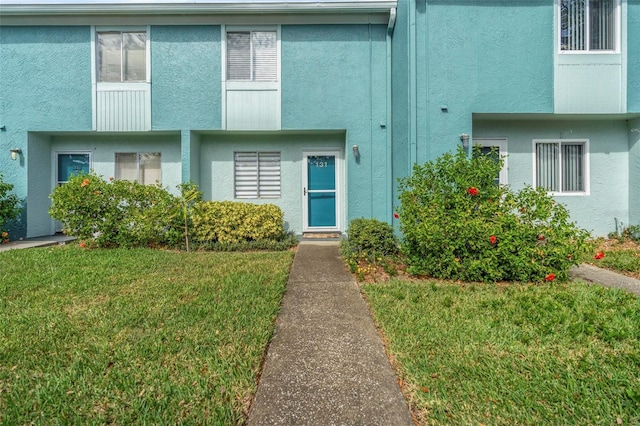 view of exterior entry featuring a lawn