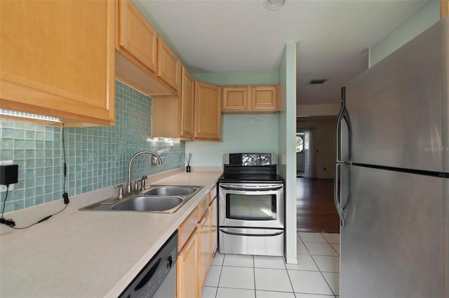 kitchen with light tile patterned flooring, stainless steel appliances, backsplash, light brown cabinets, and sink