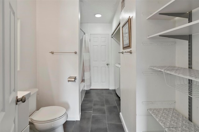 bathroom with toilet and tile patterned floors