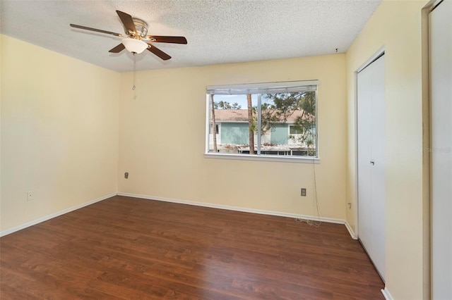 spare room featuring ceiling fan, dark hardwood / wood-style floors, and a textured ceiling