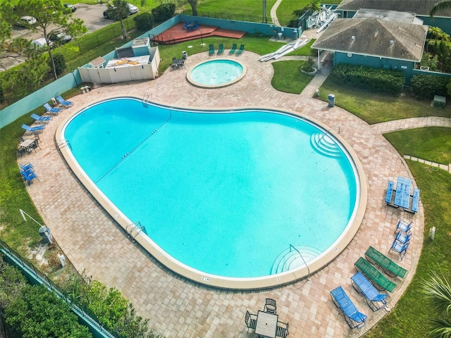 view of swimming pool with a hot tub, a patio, and a yard