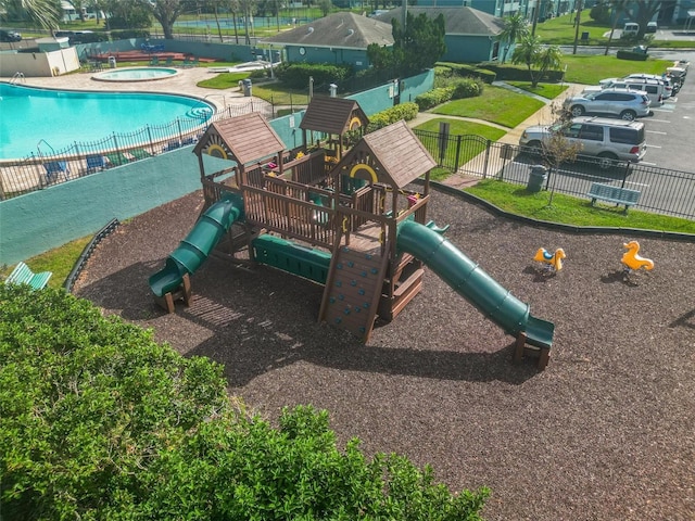 view of jungle gym featuring a pool with hot tub