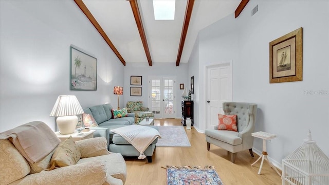 living room featuring lofted ceiling with beams, french doors, and light hardwood / wood-style floors