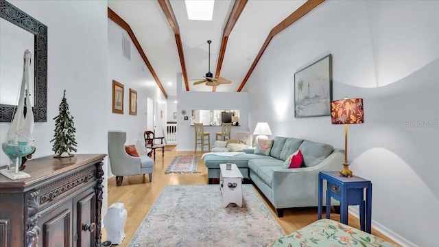 living room featuring vaulted ceiling with beams, ceiling fan, and light hardwood / wood-style flooring