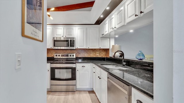 kitchen featuring tasteful backsplash, sink, white cabinets, and appliances with stainless steel finishes