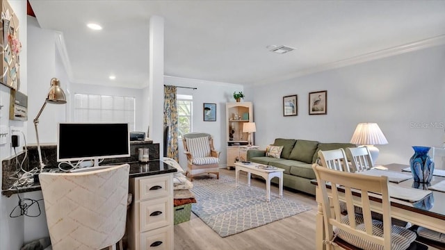 living room featuring crown molding and light wood-type flooring