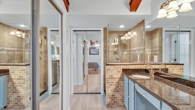 bathroom featuring wood-type flooring, vanity, and walk in shower