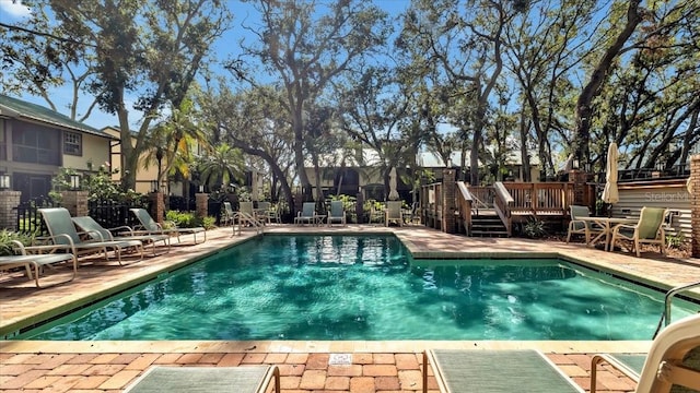 view of swimming pool featuring a deck and a patio