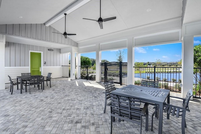 sunroom / solarium featuring vaulted ceiling with beams, a water view, and ceiling fan