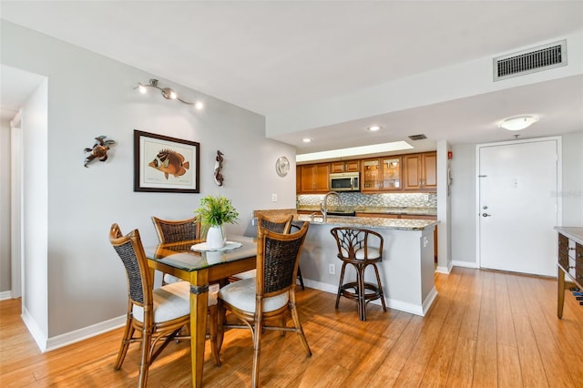 dining room with light hardwood / wood-style floors and sink