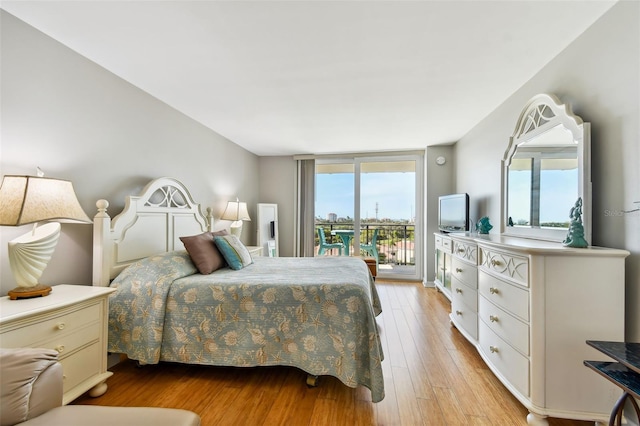 bedroom with access to exterior and light hardwood / wood-style flooring