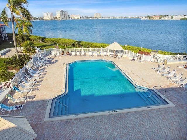 view of swimming pool with a patio area and a water view