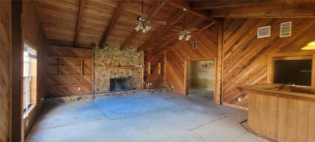 unfurnished living room featuring beam ceiling, plenty of natural light, wooden walls, and ceiling fan