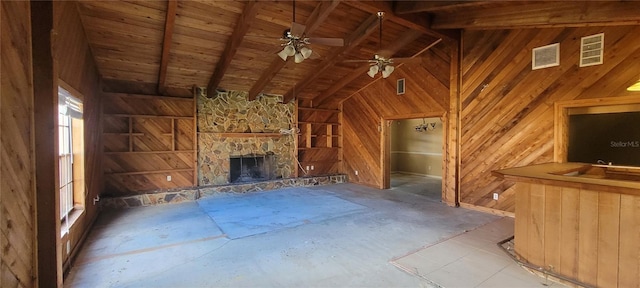 unfurnished living room with wood walls, beam ceiling, wooden ceiling, and ceiling fan