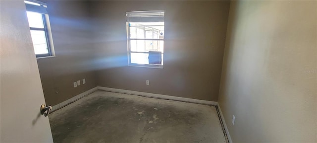 spare room with concrete floors and a wealth of natural light