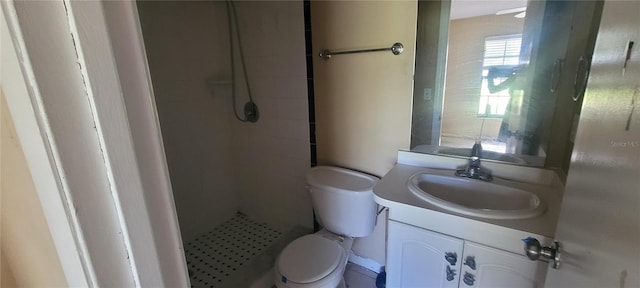 bathroom featuring vanity, toilet, and tiled shower