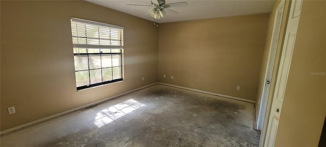 spare room with concrete floors, plenty of natural light, and ceiling fan