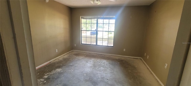 empty room featuring concrete floors, a textured ceiling, and ceiling fan