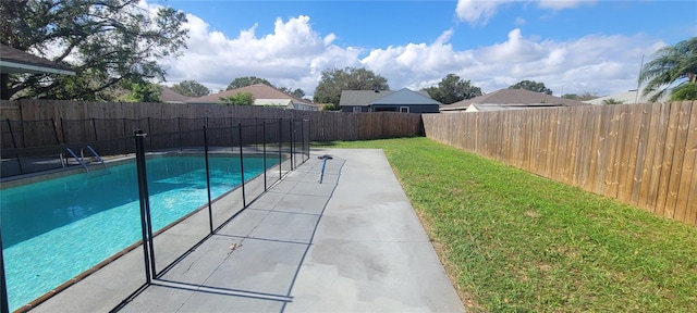 view of swimming pool featuring a patio and a lawn