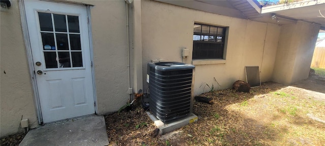 view of exterior entry featuring central air condition unit