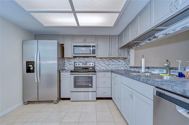 kitchen featuring appliances with stainless steel finishes, gray cabinetry, sink, and backsplash