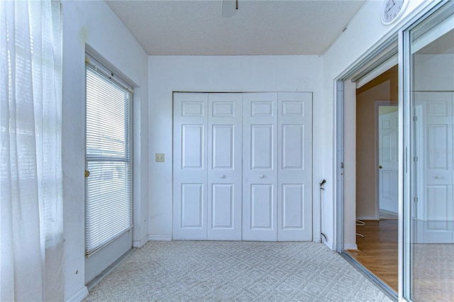 unfurnished bedroom with light hardwood / wood-style flooring, a closet, and a textured ceiling