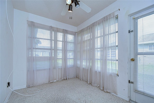 carpeted spare room featuring a textured ceiling and ceiling fan