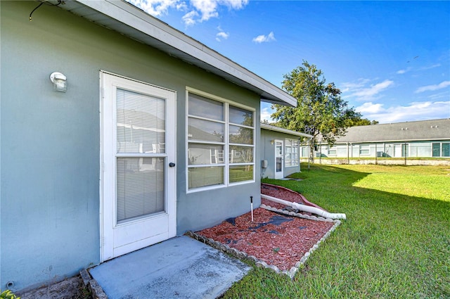 property entrance with a lawn