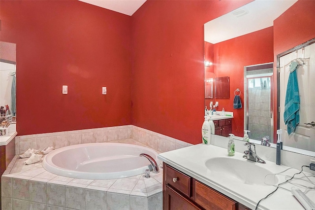 bathroom with vanity and tiled bath