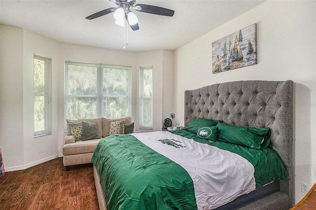 bedroom featuring multiple windows, dark hardwood / wood-style floors, and ceiling fan