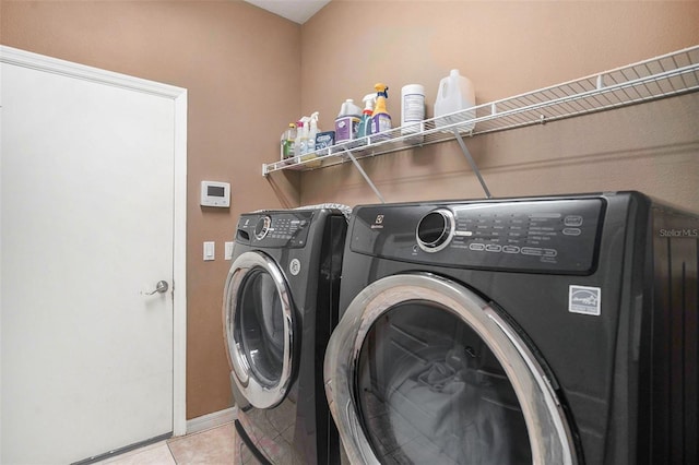 laundry room with washing machine and dryer and light tile patterned flooring