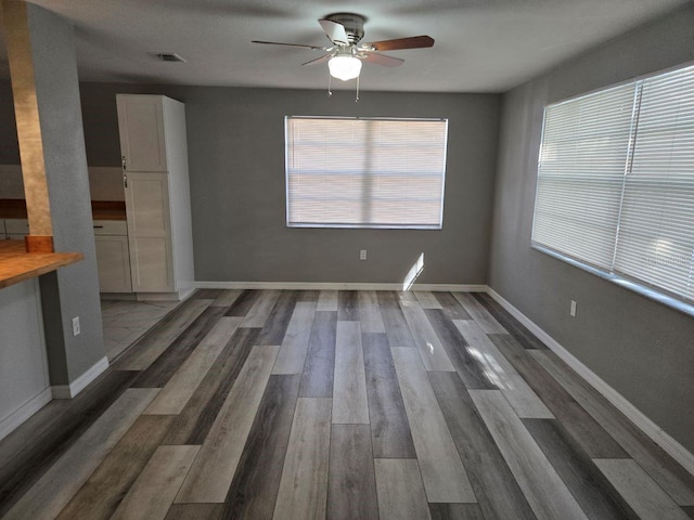 empty room featuring dark wood-type flooring and ceiling fan